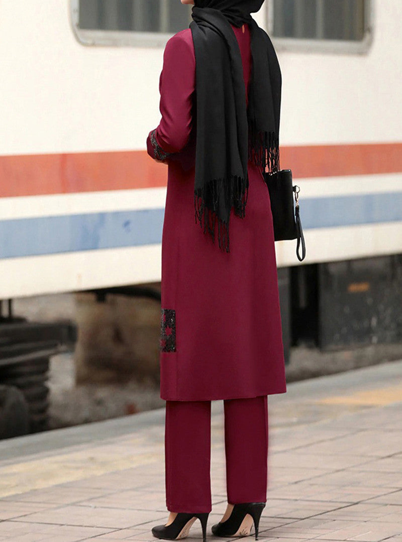 Back view of woman wearing maroon modest tunic set, black hijab, purse, and high heels.
