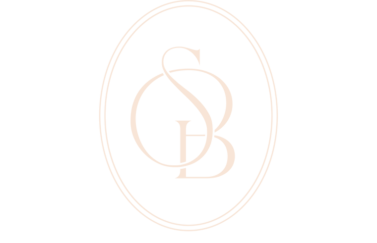 A minimalist white background featuring a light beige outline of a vertical oval frame with the letters 'GS' in a clean serif font at the center.